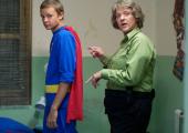 Chris Lilley as Gran with one of her juvenile charges in superhero pyjamas