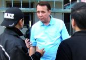 Mikhail Pletnev is questioned by a Thai police officer in front of the muscian's Pattaya residence