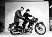 Charles and Ray Eames posing on a Velocette motorcycle, 1948