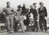 Pressburger (in glasses), Powell (gripping tripod), and crew filming '49th Parallel" (1941)