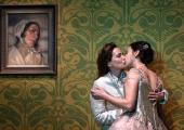 Knight of the rose Octavian (Kate Lindsey) kisses unwilling bride Sophie (Elizabeth Sutphen) beneath the portrait of her deceased mother