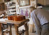 John Dilworth in his studio, working on a cello