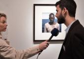 César Dezfuli is interviewed in front of his winning portrait of Amadou Sumaila