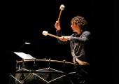 Conductor Robin Ticciati in unusual mode as bass drum MC in Harrison Birtwistle's 'Cortege'