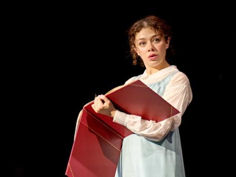 Isis Harmsworth as Thomasina, holding a large red book