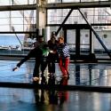 'Against the light, the dancers appear like marionettes framed within grids of glass and steel'